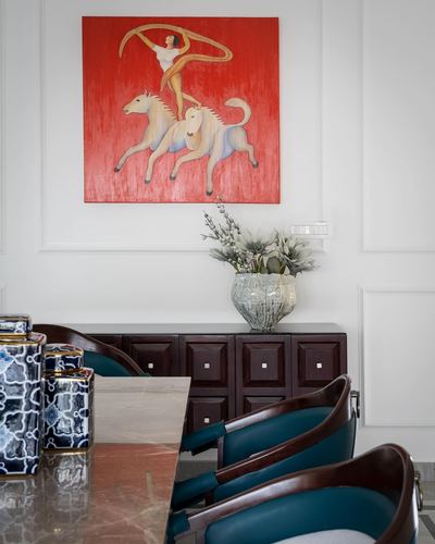 Dining room with red horse painting above dark wood sideboard and teal leather chairs