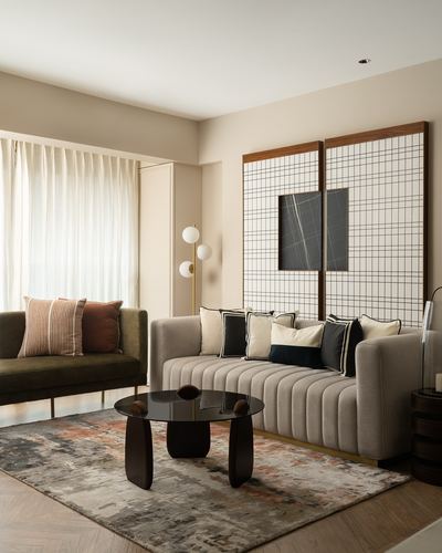 Living room with beige channel-tufted sofa, olive settee, dark round coffee table, grid panel wall art