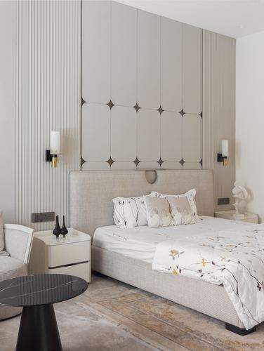 Beige bedroom with tufted panel wall, upholstered bed and marble-topped nightstands