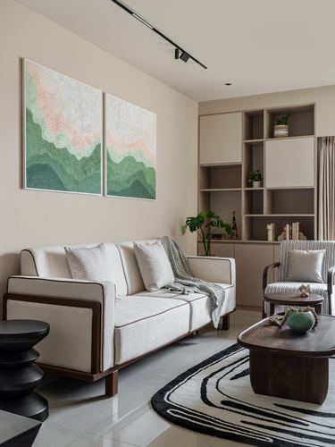 Beige living room with cream sofa, mountain-motif diptych art, and open wood shelving unit