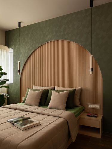 Bedroom with arched fluted wood headboard, olive textured wall, and hanging pendant lights