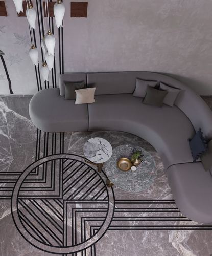 Overhead view of curved grey sofa on marble floor with black geometric inlay and flower chandelier