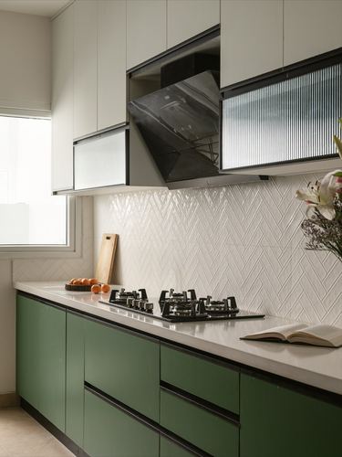 Kitchen with olive cabinetry, white chevron backsplash, gas hob, chimney hood and reeded glass shutters