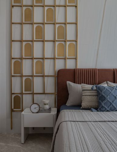 Bedroom corner with rust velvet fluted headboard beside brass arched grid screen and white nightstand
