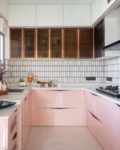 U-shaped kitchen with glossy pink cabinets, white quartz counters, and fluted glass upper cabinets
