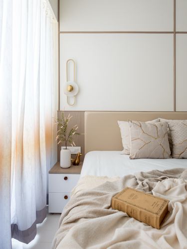 Neutral bedroom with paneled headboard wall, sheer curtains, and bedside vignette in soft light