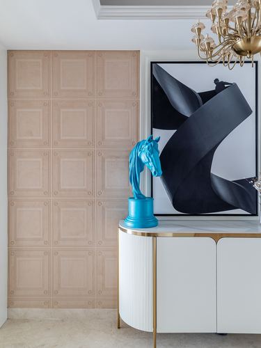 Blush paneled wall, black abstract artwork, turquoise horse head sculpture on white fluted console