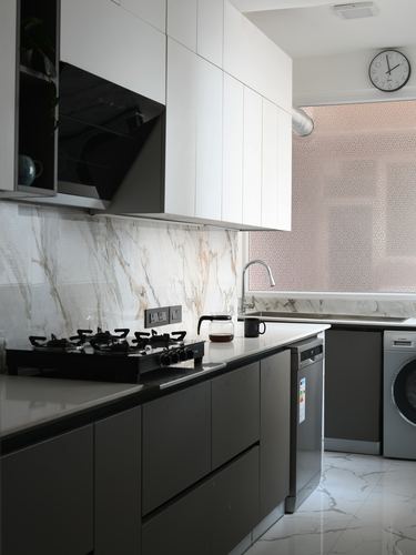 Modern grey and white kitchen with marble-look backsplash, gas hob, and integrated appliances