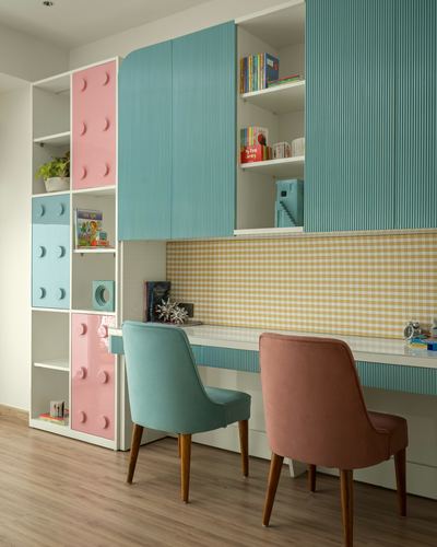 Children's study nook with teal and pink lego-panel storage, ribbed cabinets, and gingham backsplash