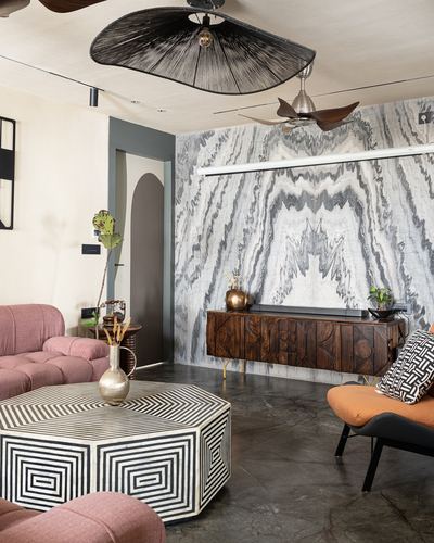 Living room with marble feature wall, carved wood sideboard, pink sofas, and inlay coffee table