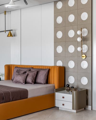 Mustard leather channel-tufted bed against white paneling and textured dotted accent wall