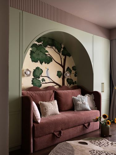 Arched niche with tree mural framing a dusty rose scalloped daybed sofa in a child's room