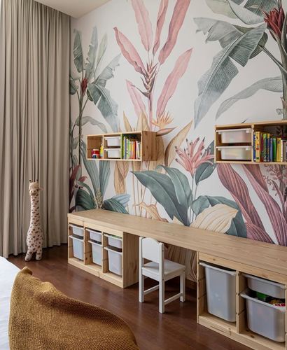 Child's play corner with botanical mural wall, wooden shelving, storage bins and white chair