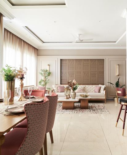 Living and dining area with carved panel wall, pink accents, and marble flooring
