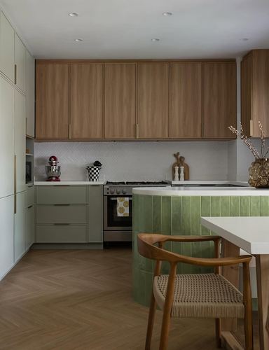 Kitchen with wood upper cabinets, sage lower cabinets, herringbone backsplash and curved green tiled island