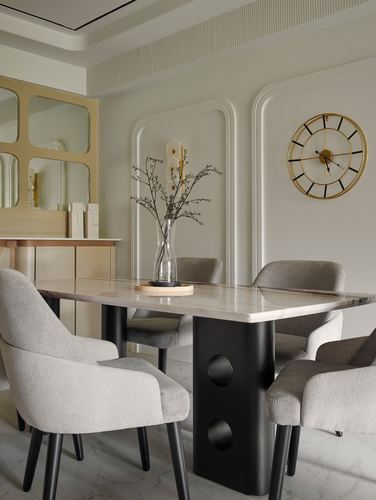 Dining room with marble table on black pedestal base, grey chairs, gold wall clock, and paneled walls
