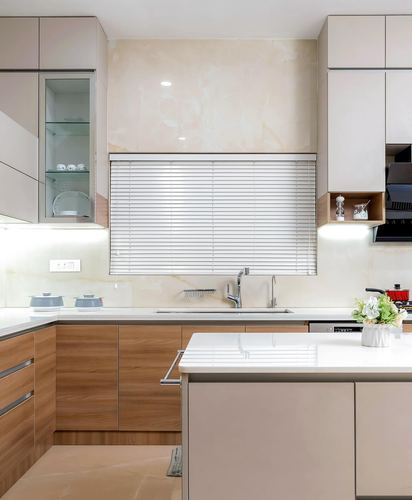 Modern beige and wood kitchen with island, stone backsplash, and window sink area