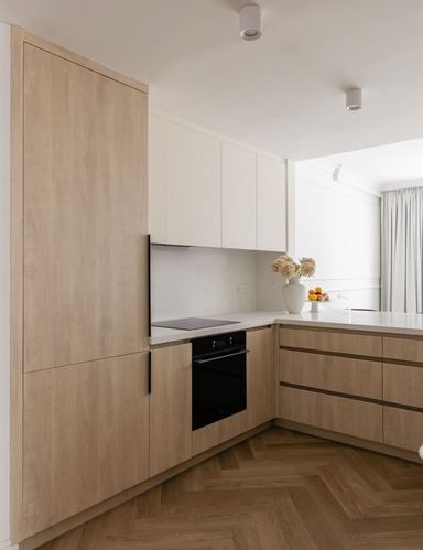 Minimalist wood and white kitchen with herringbone floor and built-in oven