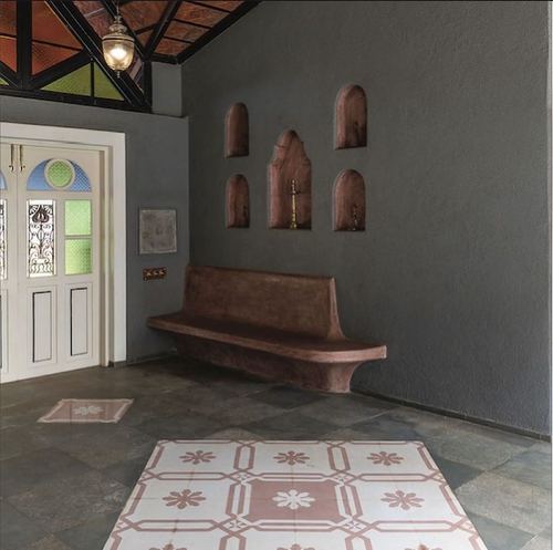 Foyer with arched wall niches, terracotta bench, and patterned cement tile flooring