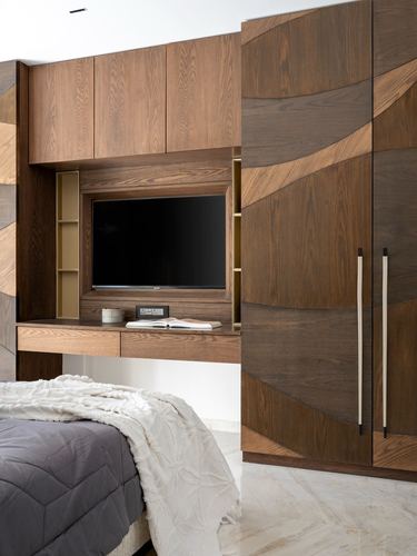 Wooden bedroom media wall with wave-patterned wardrobe and marble flooring