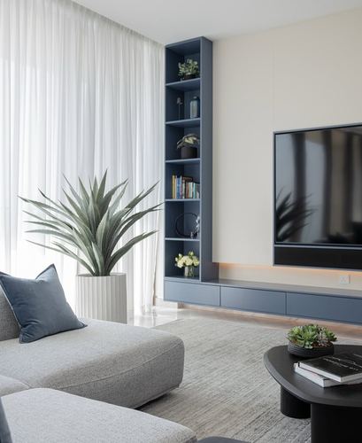 Modern living room with blue TV wall unit, sheer curtains, and grey sectional sofa