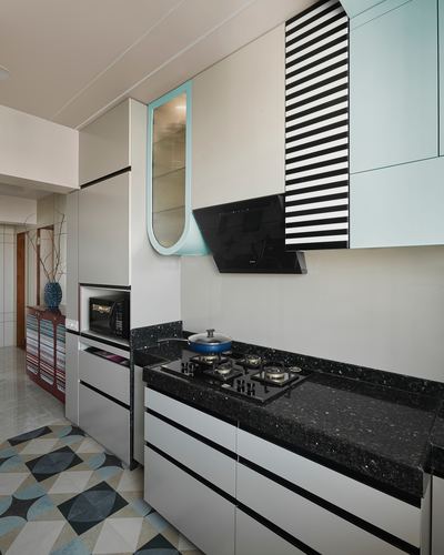 Modern galley kitchen with black stone counter, striped panel, and patterned floor tiles