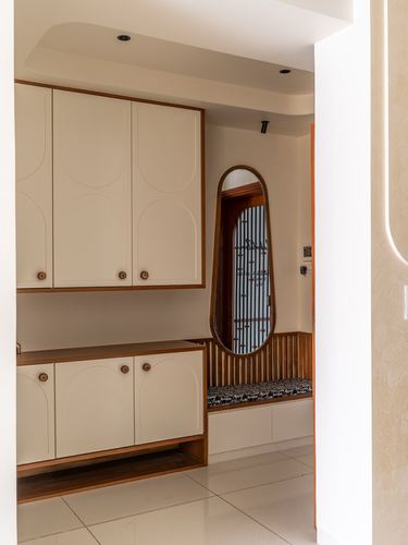 Cream foyer cabinetry with arched wooden mirror niche and slatted bench seat