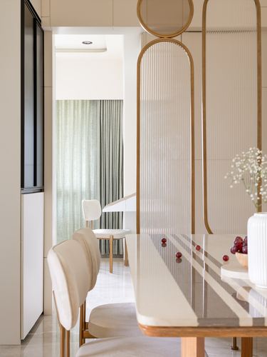 Dining table with reeded glass divider, sage curtains visible through doorway beyond