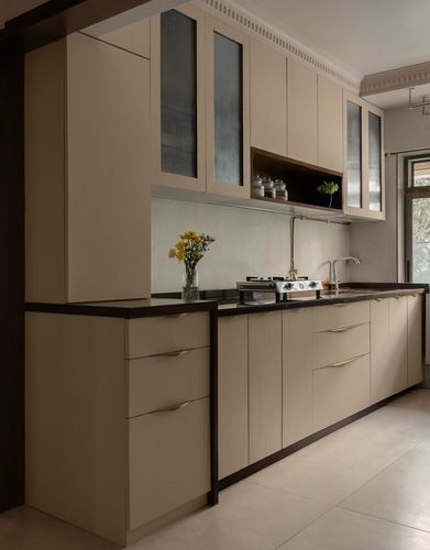 Beige galley kitchen with dark countertop, reeded glass cabinets and open display shelf