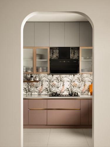 Kitchen with mauve cabinetry and floral mural backsplash viewed through an arched doorway