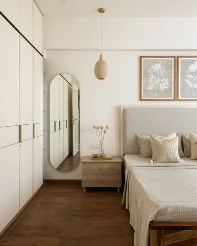 Bedroom with cream wardrobe, oval mirror, wood nightstand and upholstered bed