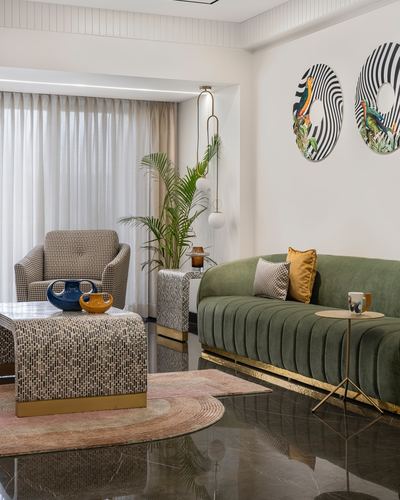 Living room with olive green channel-tufted sofa, houndstooth armchair, mosaic coffee table, and round patterned wall art.