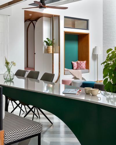 Bengaluru dining counter with curved green base, marble top, teal window seat nook behind