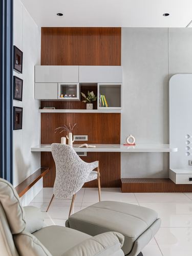 Home study nook with wood panelling, floating white desk, and boucle chair