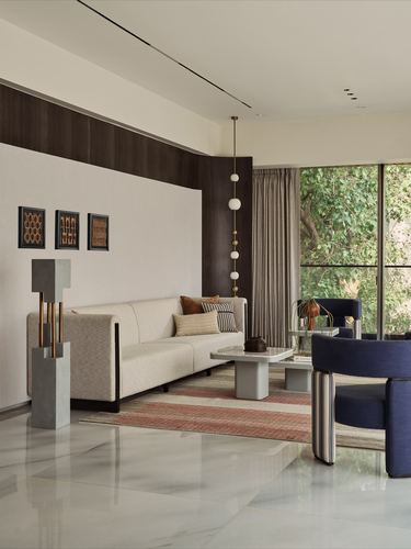 Living room with cream sofa, navy armchairs, marble coffee table and floor-to-ceiling green view