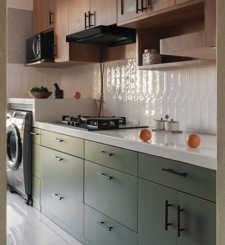 Kitchen with sage green lower cabinets, wood upper units, and picket tile backsplash lit by daylight
