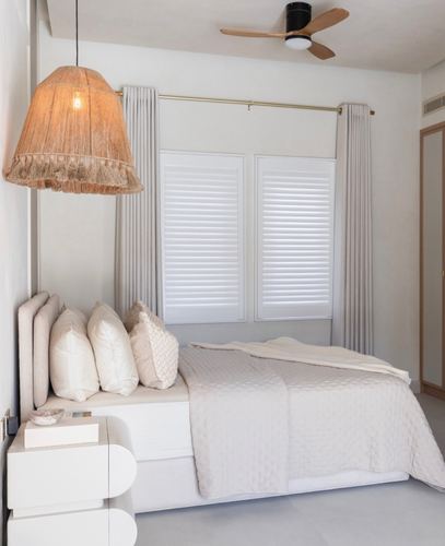 Minimalist neutral bedroom with jute pendant lamp, white shutters, and quilted bedding