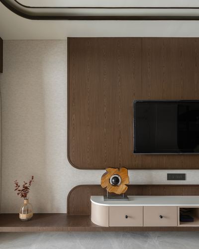 Curved wood-panelled TV wall with beige cabinet and wooden sculpture in modern living room