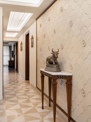 Marble corridor with carved console table holding a bronze nandi statue against a textured stone wall