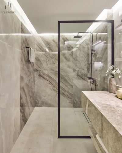 Marble-look bathroom with black-framed glass shower and floating stone vanity