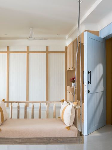 Entryway swing bench beside slatted white wall and pale blue door