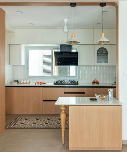 U-shaped wooden kitchen with island, two pendant lights, and patterned tile floor inset