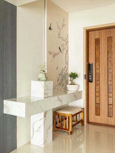 Foyer with marble-look console table, bird and floral mural, and wooden entry door