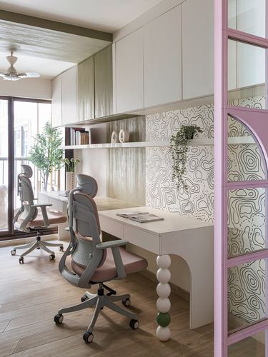 Twin desk study with pink ladder frame, ergonomic chairs, and topographic wallpaper backsplash