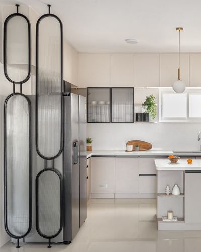 Modern L-shaped kitchen with island, steel fridge, and oval fluted-glass partition screen