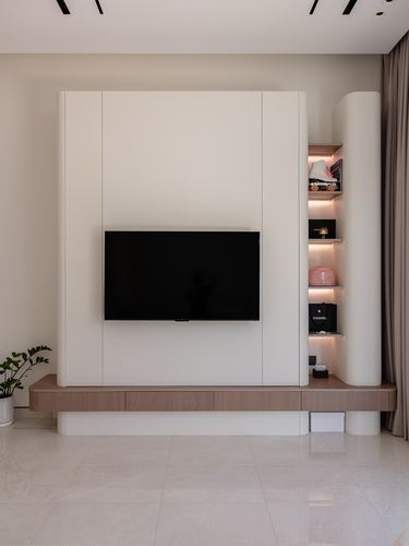 Minimalist living room with wood-fronted TV console and curved backlit display niche