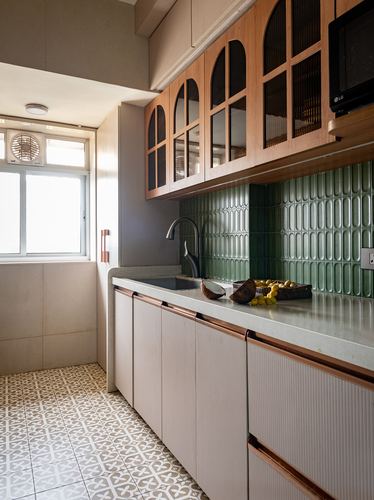 Galley kitchen with arched glass cabinets, green scalloped tile backsplash, and patterned floor tiles