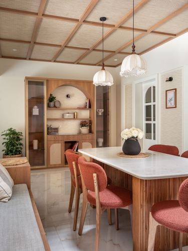 Dining room with fluted wood table, terracotta chairs, arched wood cabinet, and coffered ceiling