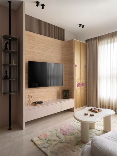 Living room with stone-clad tv wall, patterned gold cabinet, and sculptural boucle coffee table on a floral rug