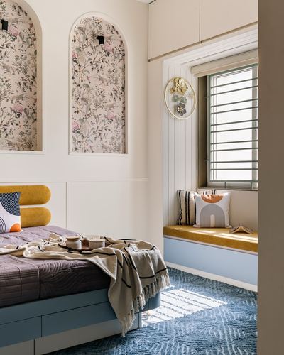 Bedroom with arched floral niches, mustard headboard, and blue window seat nook
